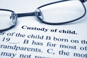 Reading glasses laid on a legal document regarding custody