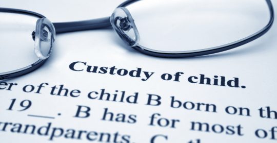 Reading glasses laid on a legal document regarding custody 