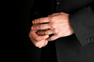 close up of mature man's hands removing wedding ring